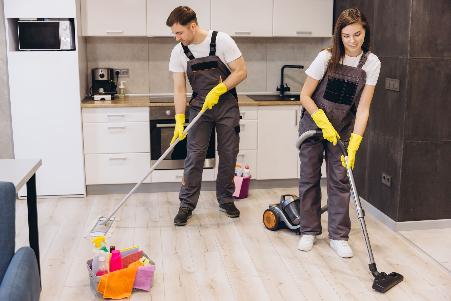 Cleaning company workers washing floor and vacuuming apartment